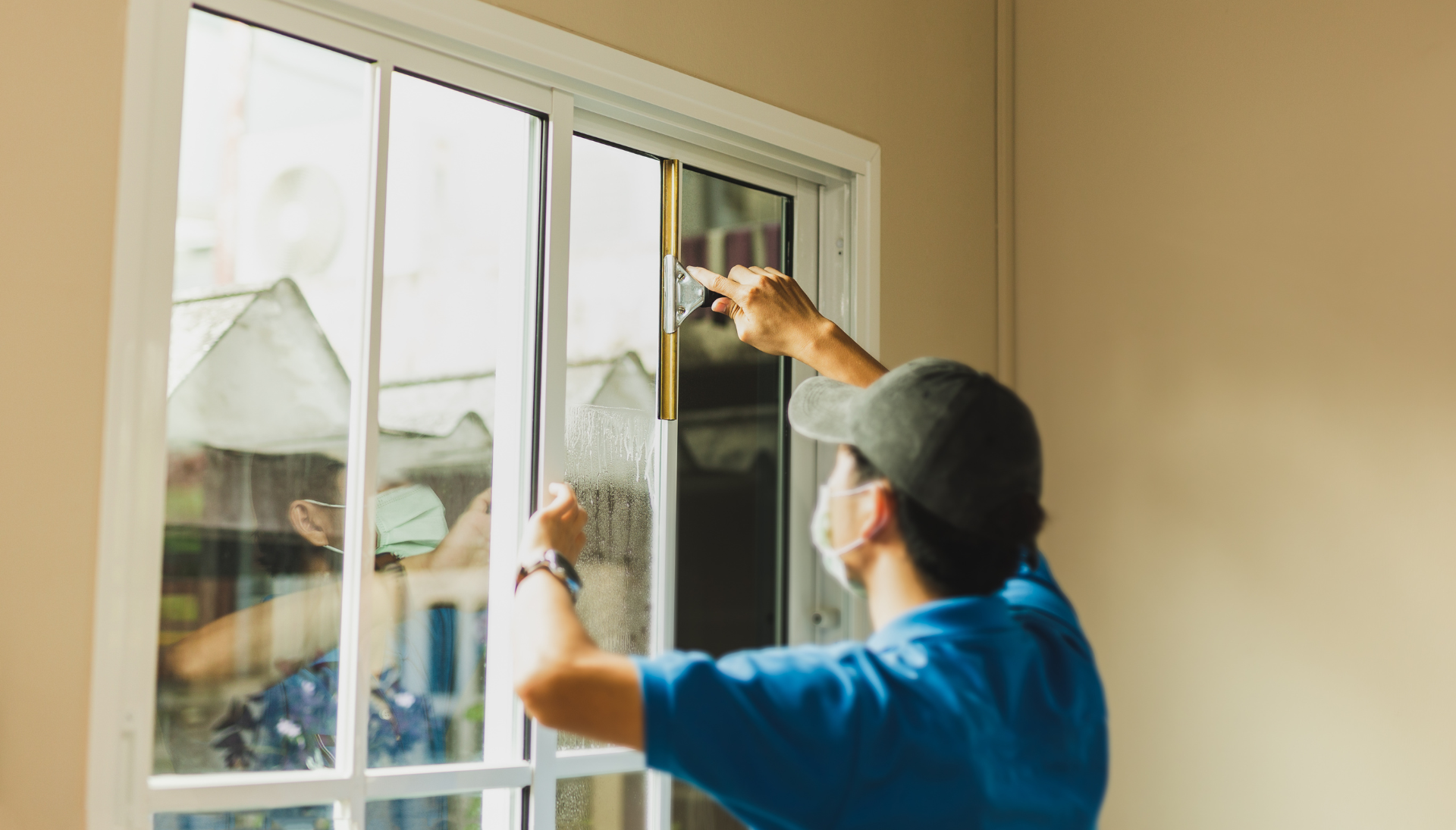 A man is cleaning a window with a squeegee.