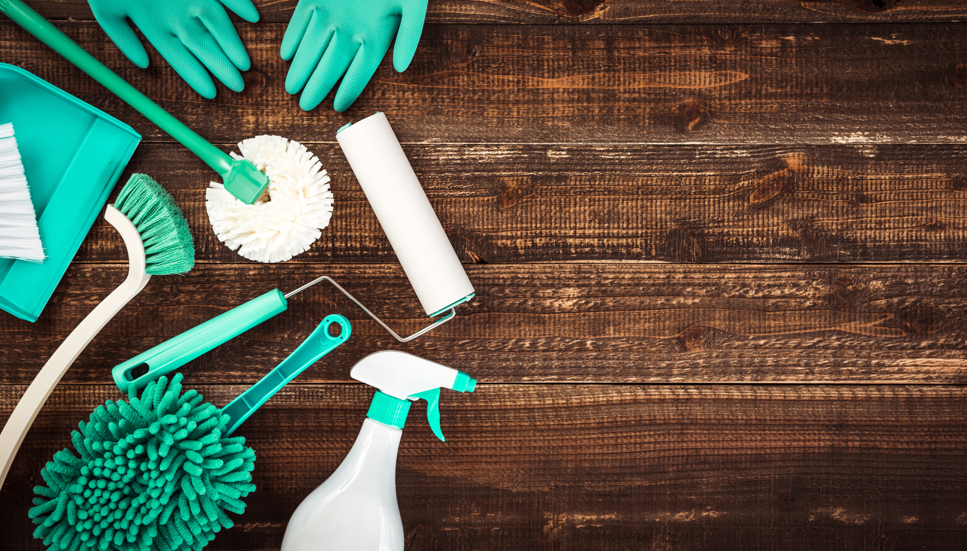 A wooden table topped with cleaning supplies and gloves.