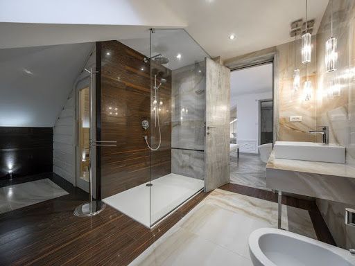 A bathroom with a walk in shower , sink and toilet.
