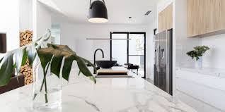 A kitchen with a marble counter top and a vase of flowers on it.