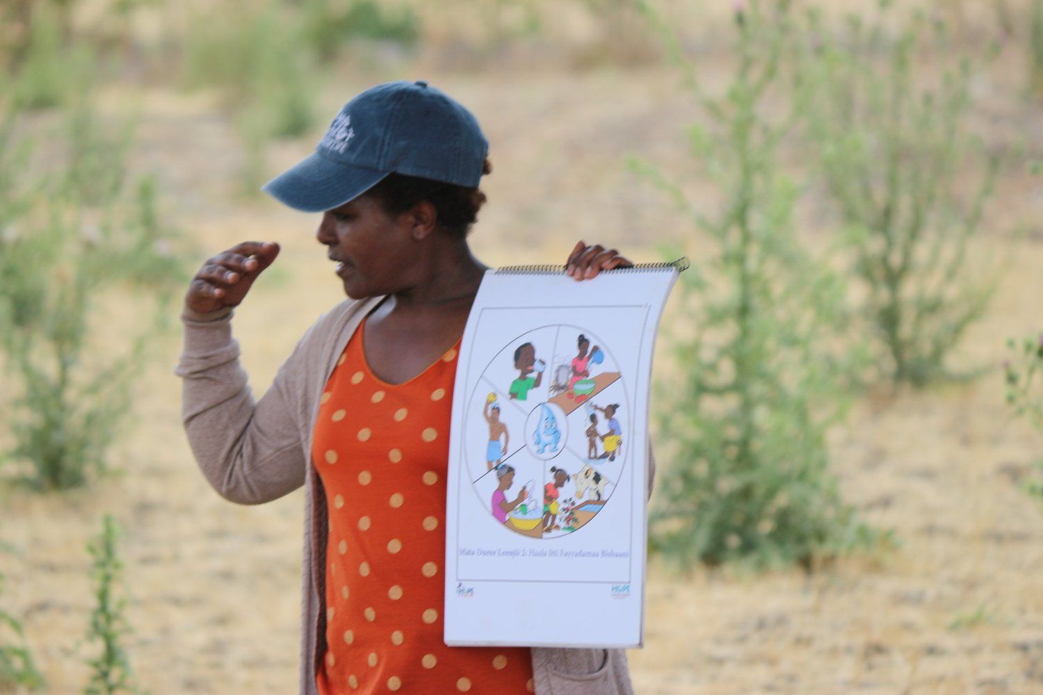 A woman is holding a drawing of a circle in her hand.