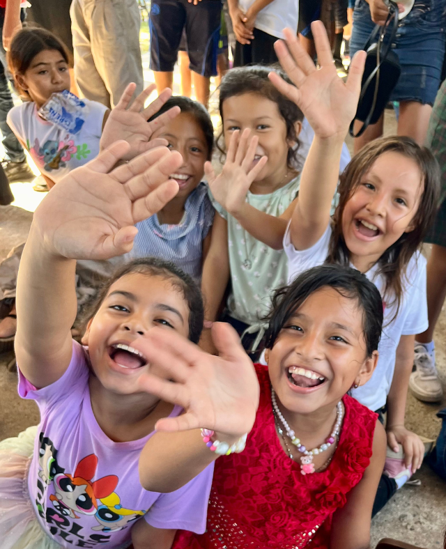 A group of young girls are waving their hands in the air
