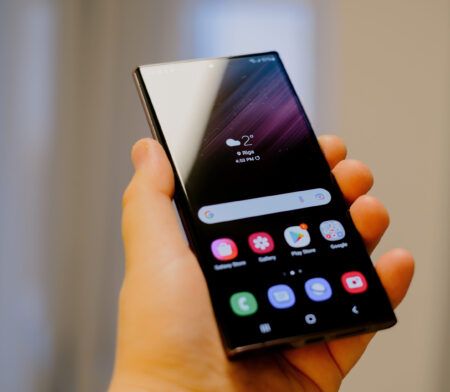 Hönd heldur á Samsung Galaxy snjallsíma með táknum sýnilegum á skjánum.