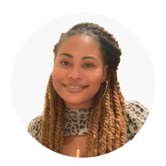Woman with brown twisted braids, smiling, wearing a leopard print top and gold hoop earrings.