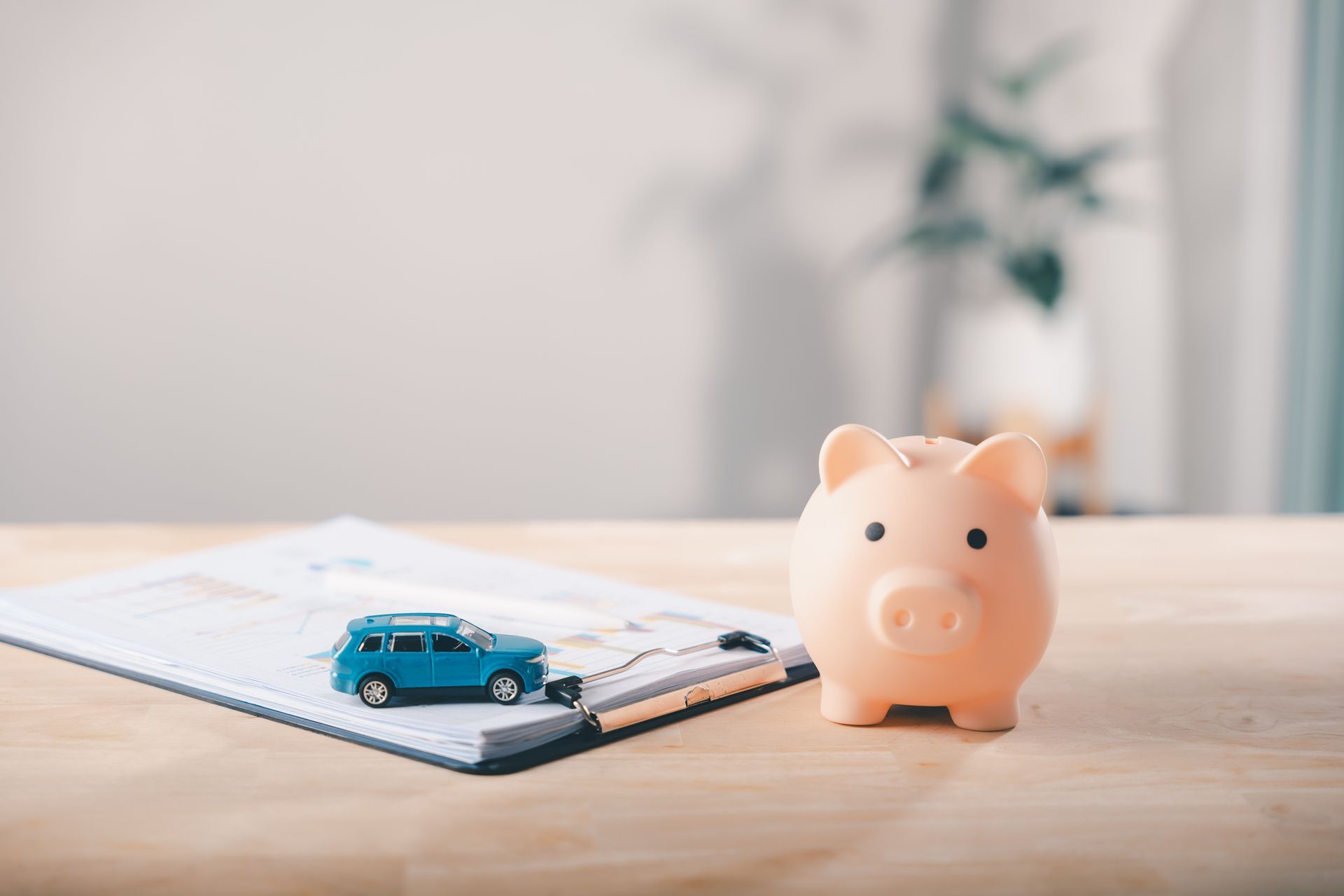 Piggy bank and toy car on financial documents representing personal installment loan savings in Aust