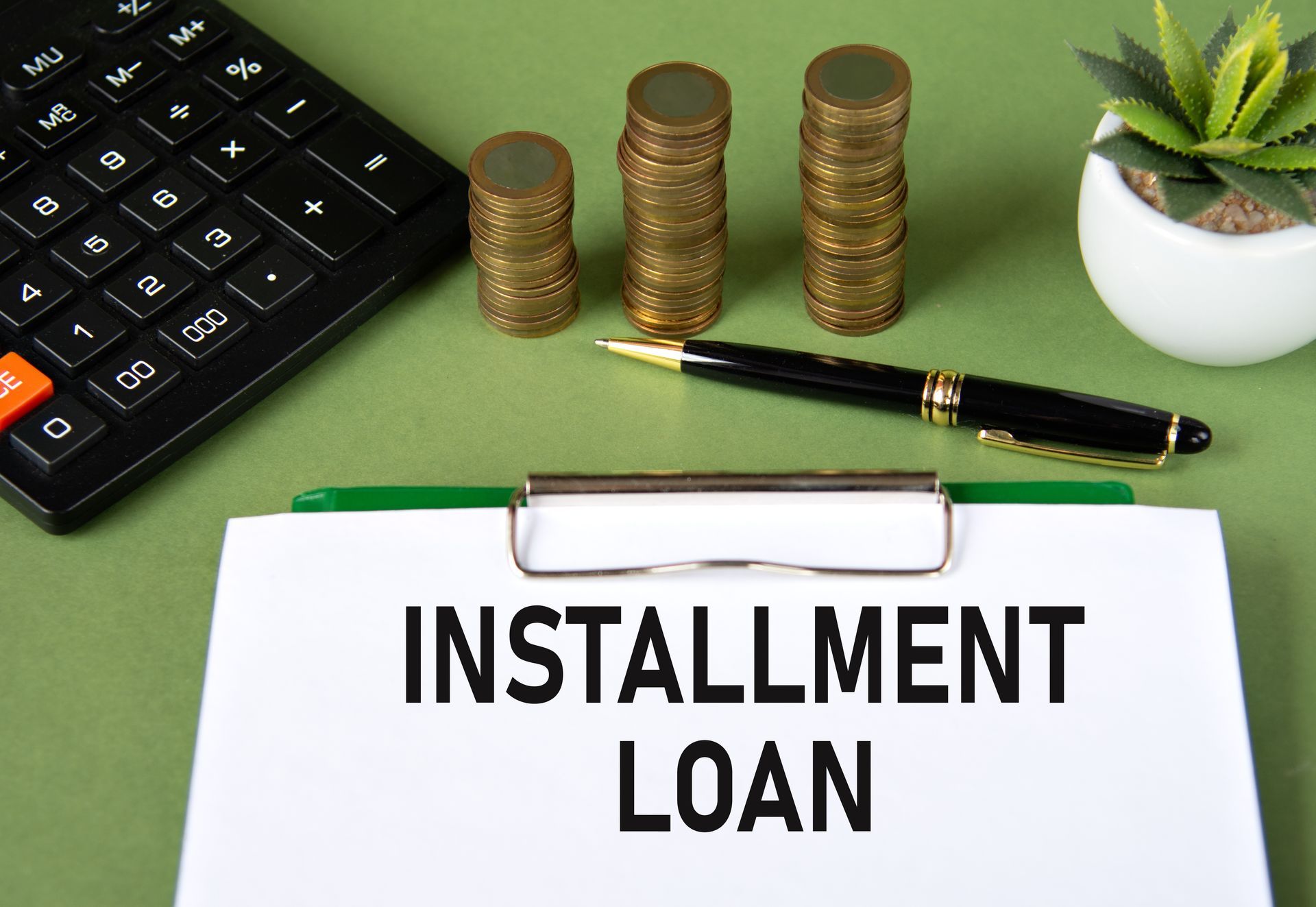 Installment loan concept with coin stacks and calculator.