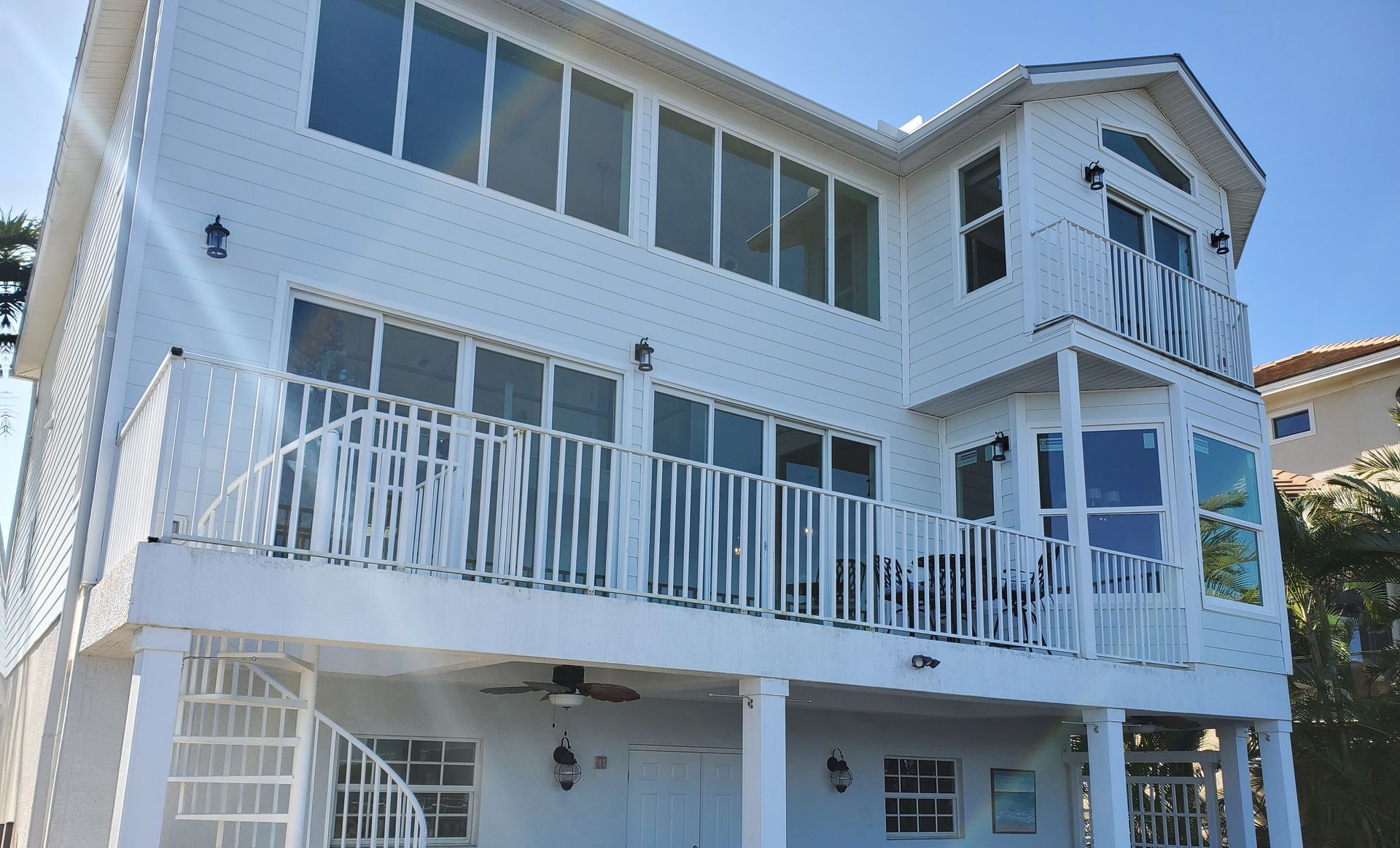 A large white house with a balcony and stairs