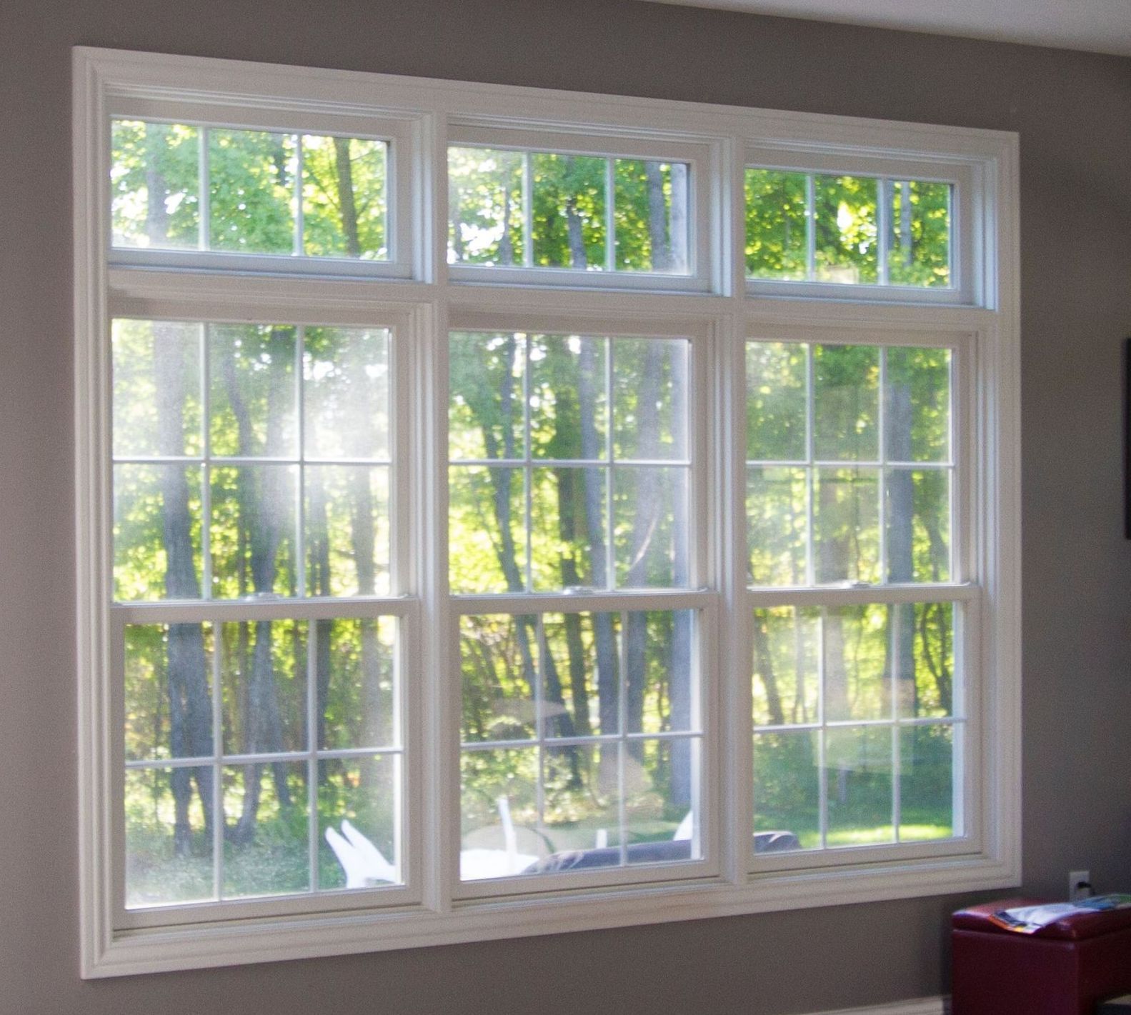 A living room with a lot of windows and trees in the background