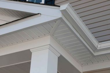 A close up of the corner of a house with a porch and gutters.
