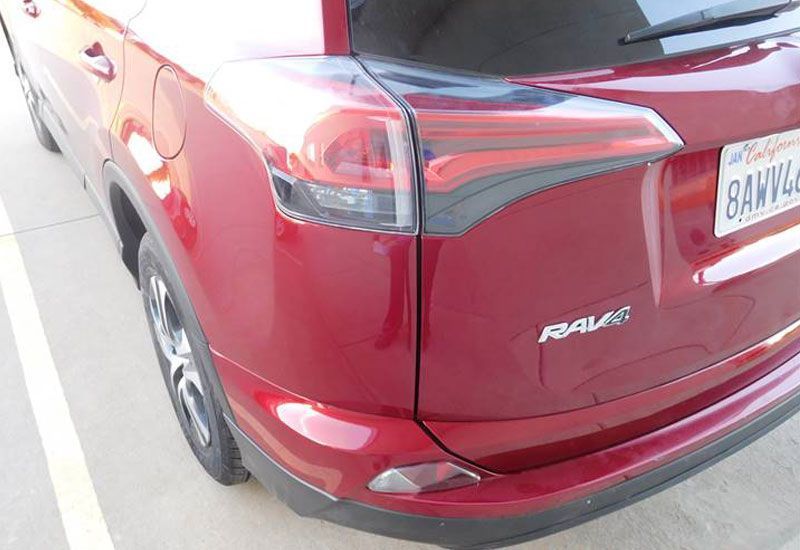 A red toyota rav4 is parked in a parking lot.