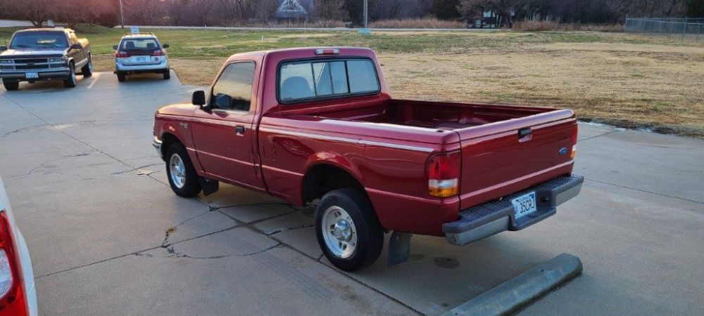 A red pickup truck is parked in a parking lot.