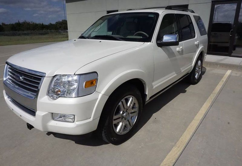 A white ford explorer is parked in a parking lot
