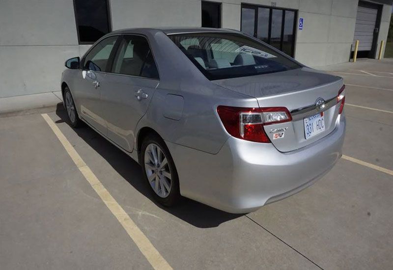 A silver car is parked in a parking lot