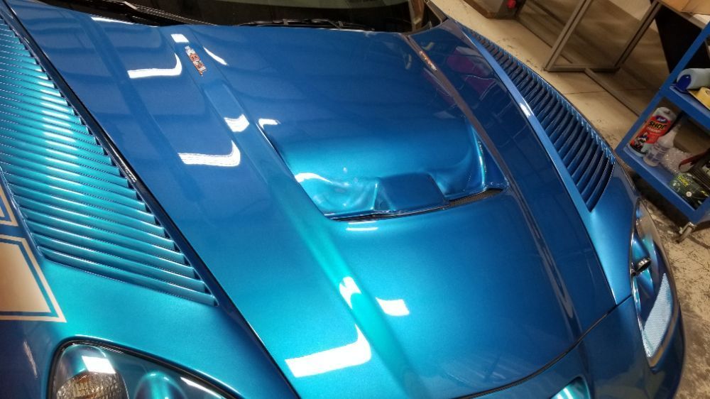 A close up of a blue car with a hood