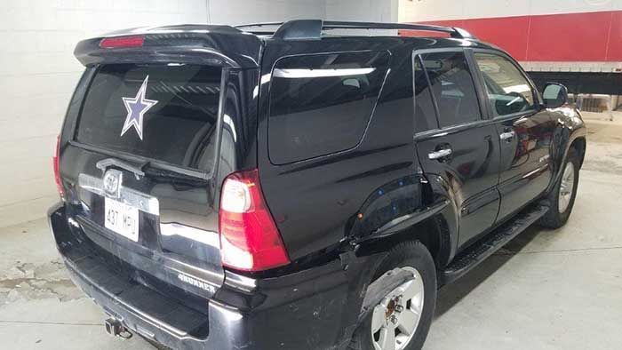 A black suv with a star on the back window is parked in a garage.