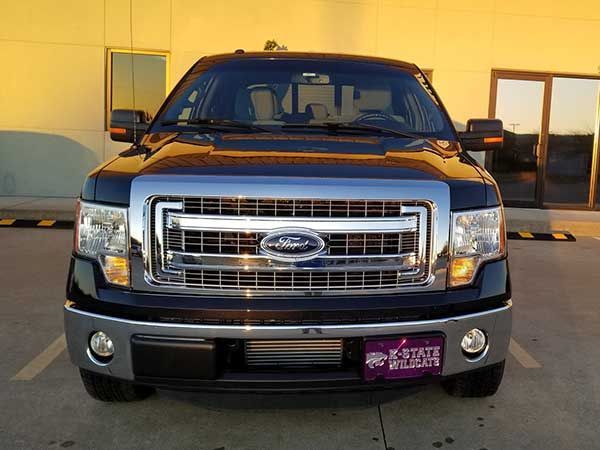 A black ford truck is parked in a parking lot