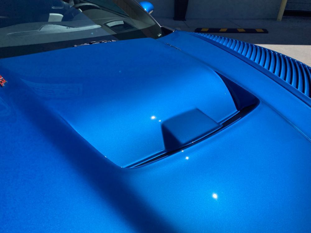 A close up of the hood of a blue car