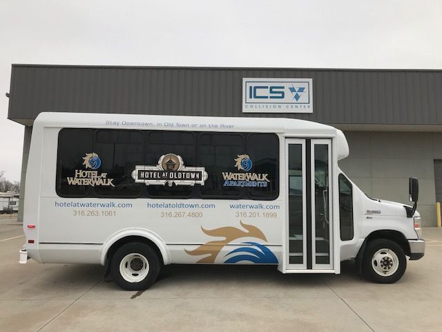 A white bus is parked in front of a building.