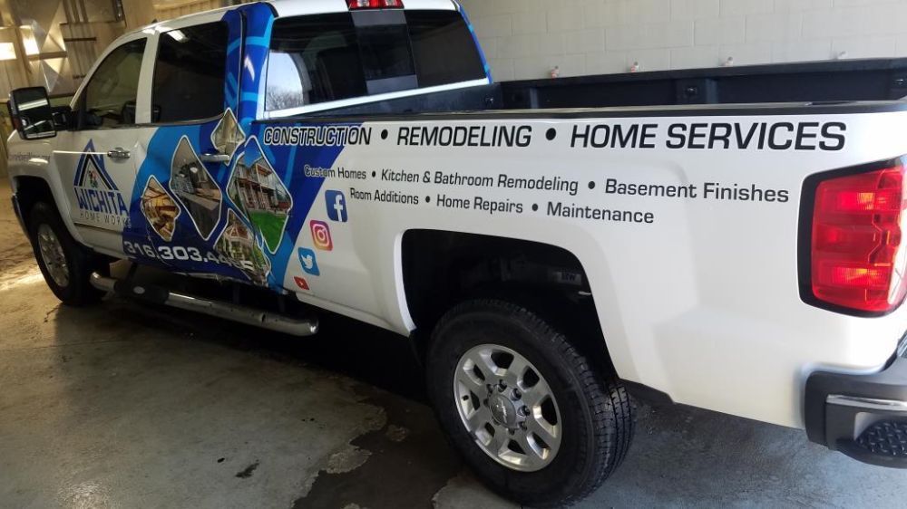 A white truck with a sticker on the back that says home services.