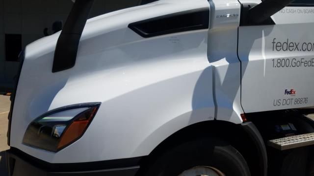 A white fedex truck is parked in front of a building