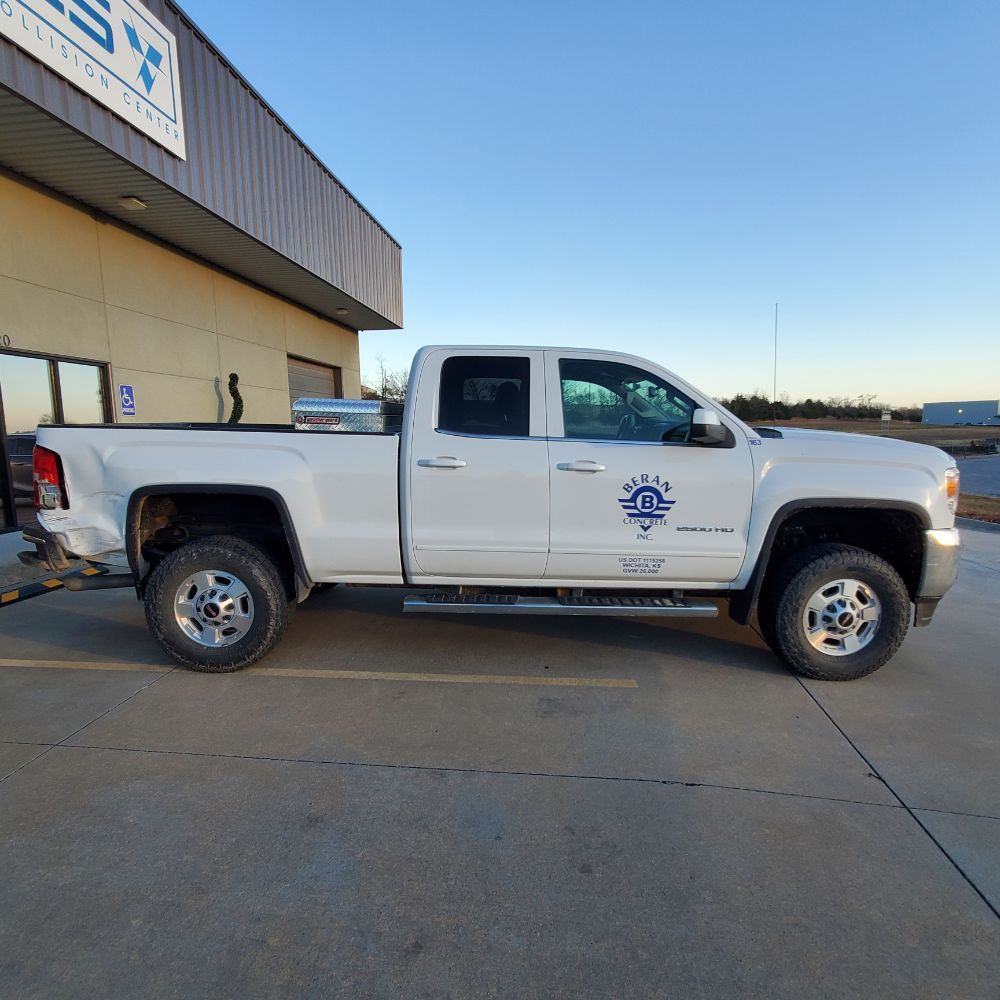 A white truck is parked in front of a building