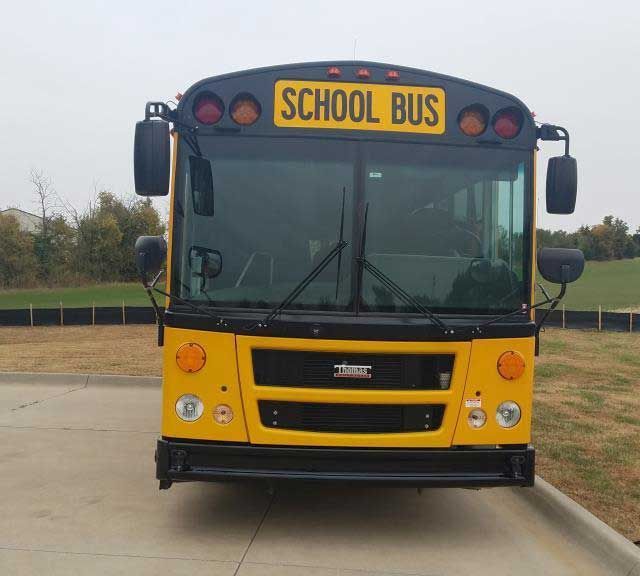 A yellow school bus is parked in a parking lot
