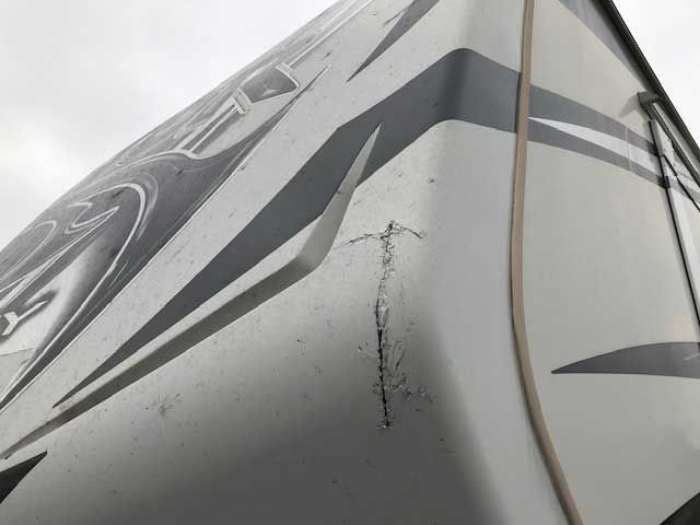 A close up of a damaged side of a rv.