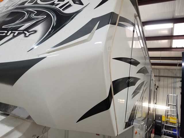 A white and black rv with the number 27 on it