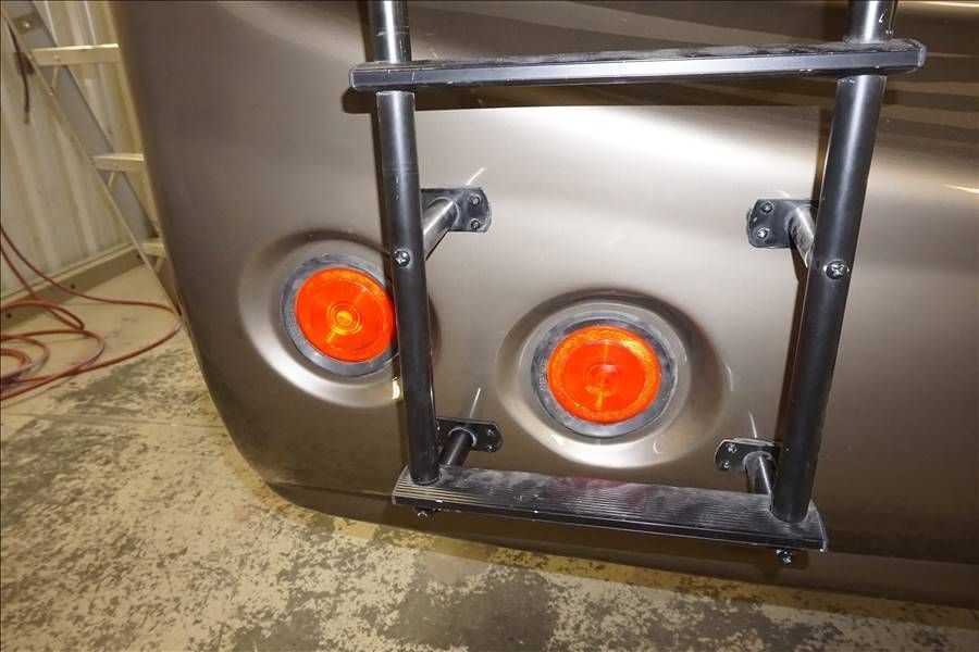 A close up of a car with a ladder attached to it.