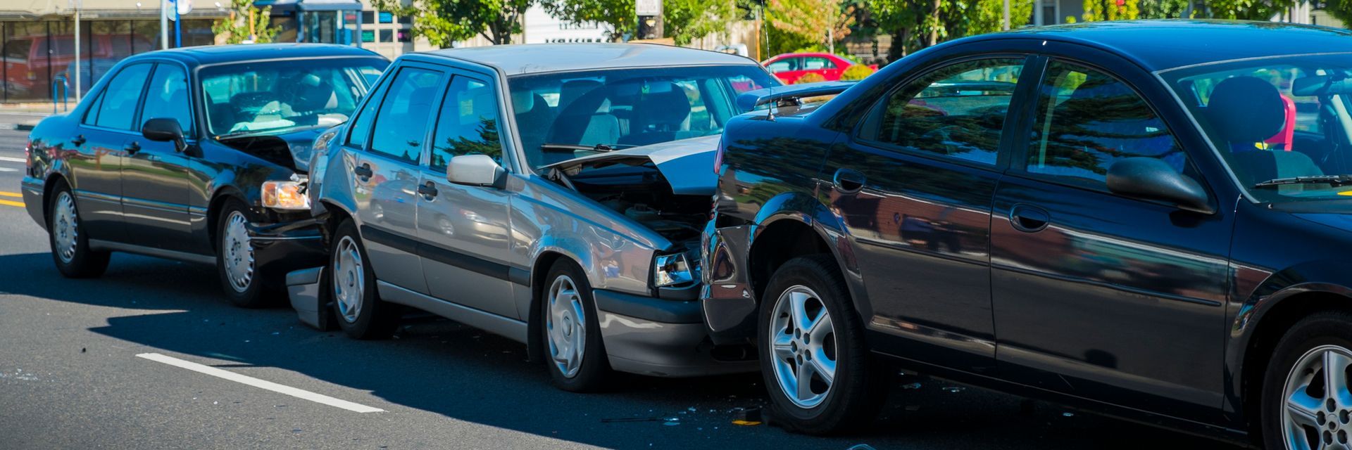 A row of cars are parked on the side of the road.