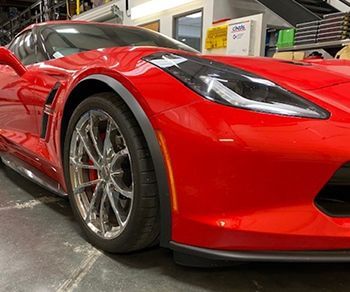 A red sports car is parked in a garage.