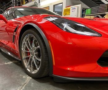 A red sports car is parked in a garage.