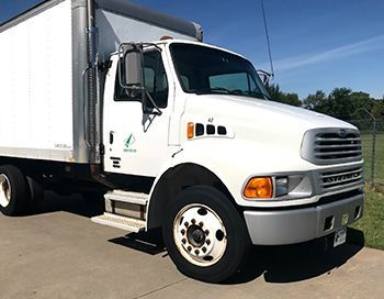 A white semi truck is parked on the side of the road.