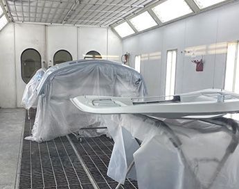 A car is being painted in a paint booth.