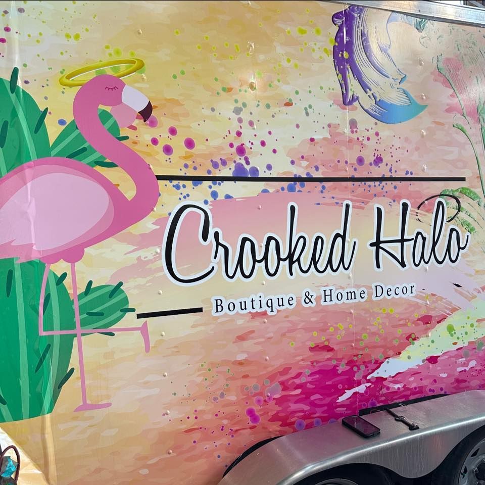 A pink flamingo is on the side of a truck that says crooked halo