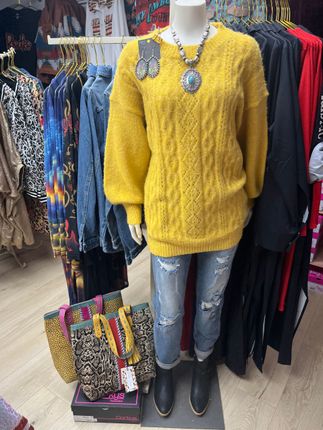 Two cowboy shirts are hanging on mannequins in a store