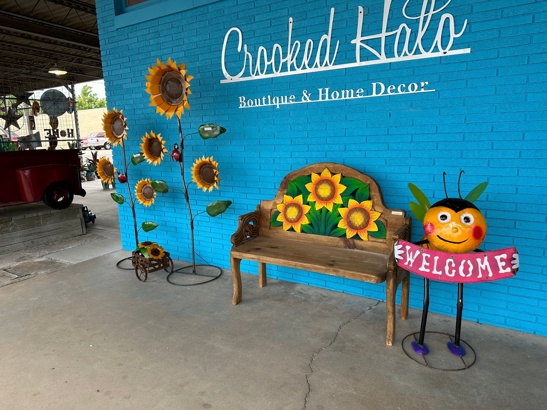 A blue brick wall with a bench and a welcome sign