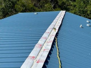 A blue metal roof with a rope attached to it.