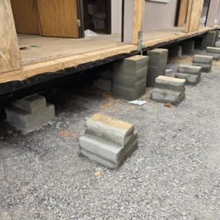 A row of concrete blocks are sitting on the ground next to a building under construction.