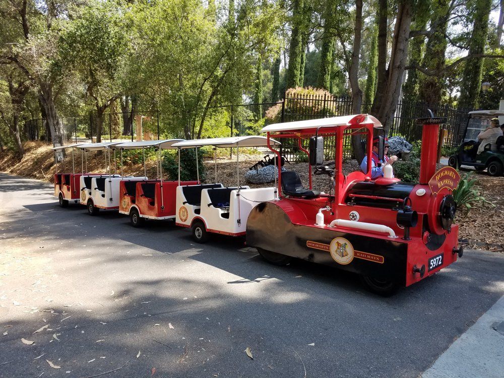A red and white train is parked on the side of the road.