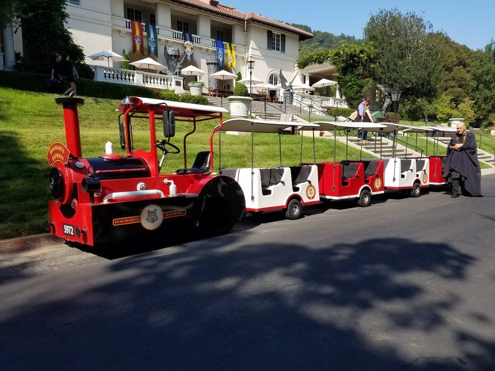 A red and white train is parked on the side of the road