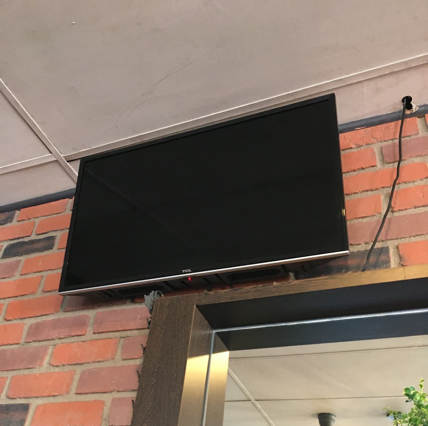 A Flat Screen Tv is Mounted on a Brick Wall — Hendo's TV Antennas & Installations in White Rock, QLD