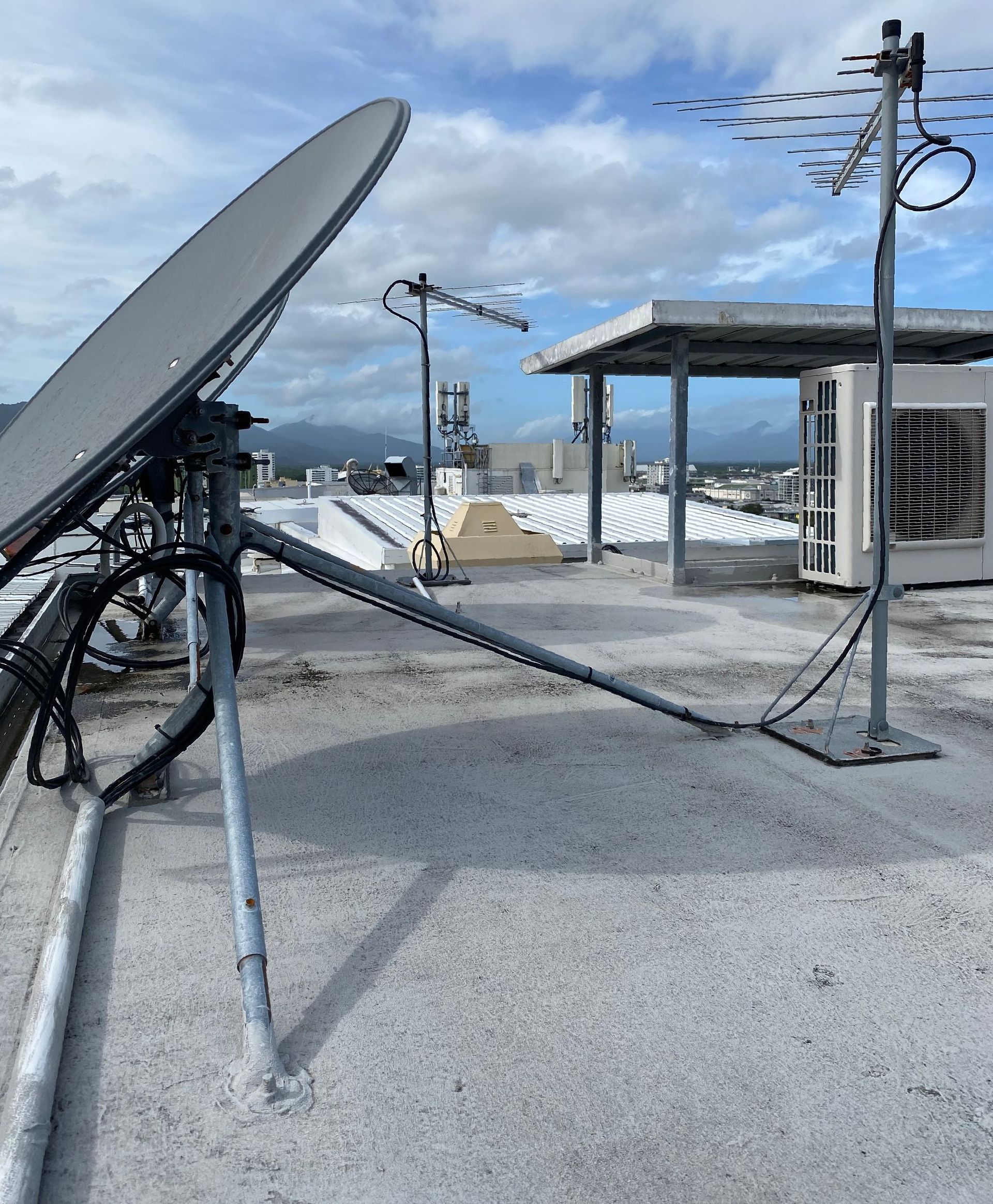 A White Rv With a Satellite Dish on Top of It is Parked in a Driveway — Hendo's TV Antennas & Installations in Trinity Beach, QLD