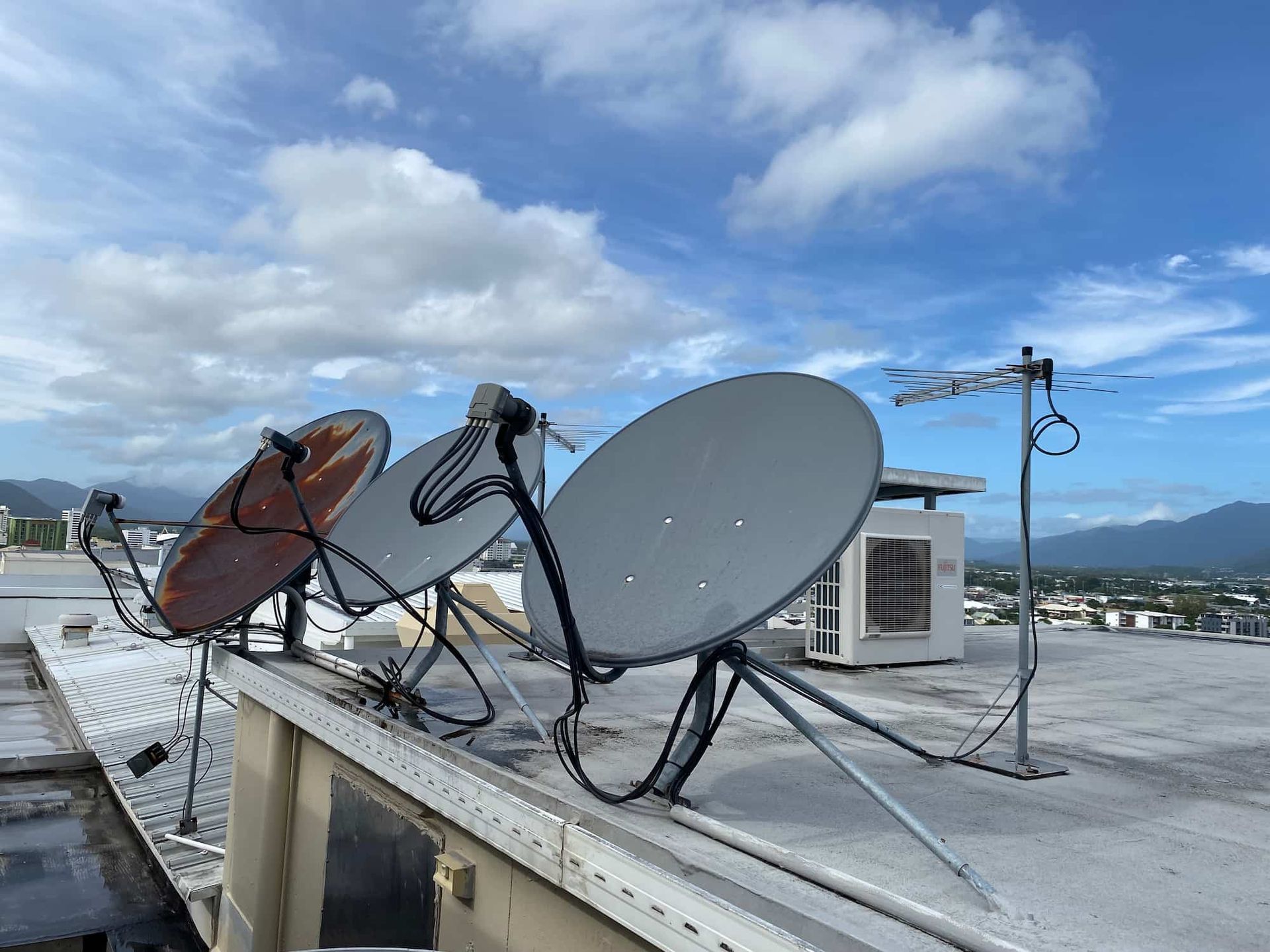 A Row of Satellite Dishes Are Sitting on Top of a Roof — Hendo's TV Antennas & Installations in Tablelands, QLD
