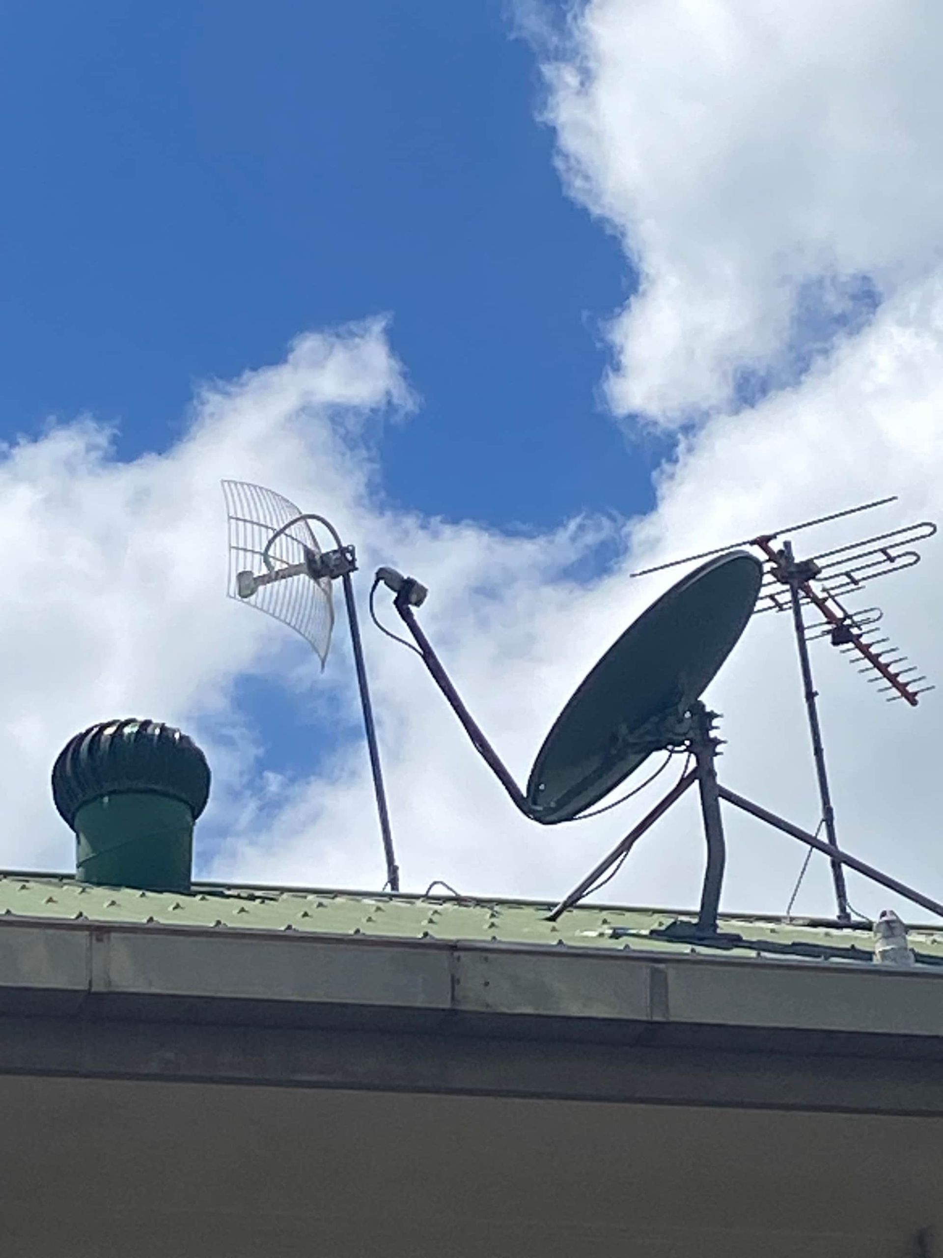 A Satellite Dish is Sitting on Top of a Green Roof — Hendo's TV Antennas & Installations in White Rock, QLD