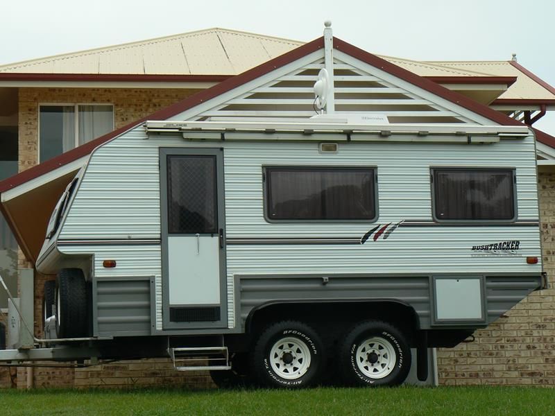 A Camper Trailer is Parked in Front of a House — Hendo's TV Antennas & Installations in White Rock, QLD