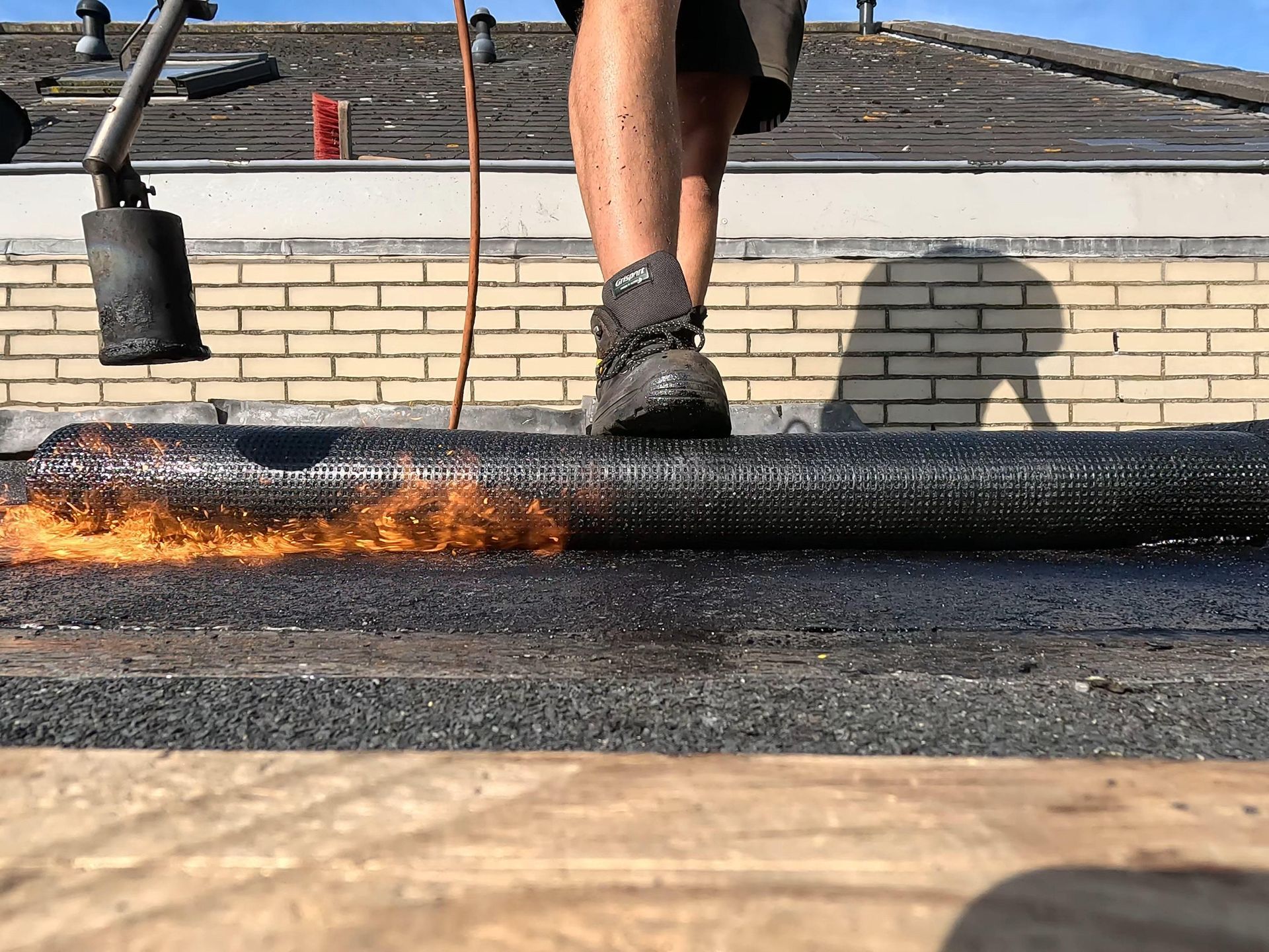 Een persoon staat op een dak met een fakkel.