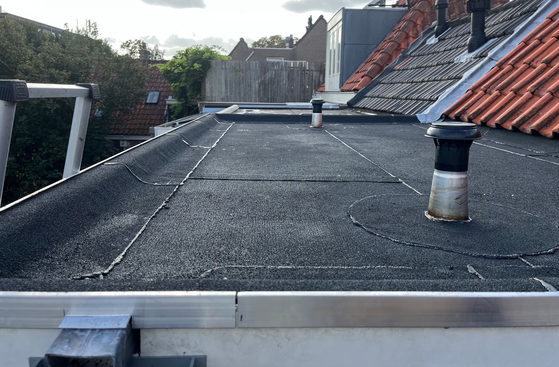 Een dak met een zwart dak en een schoorsteen erop