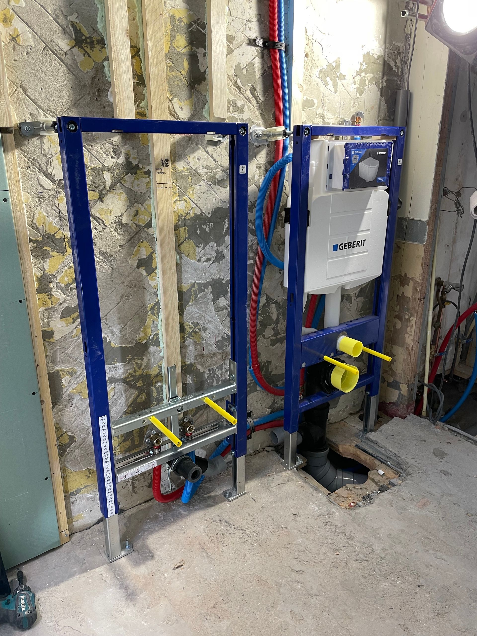 Een badkamer met een wandtoilet en een ladder.