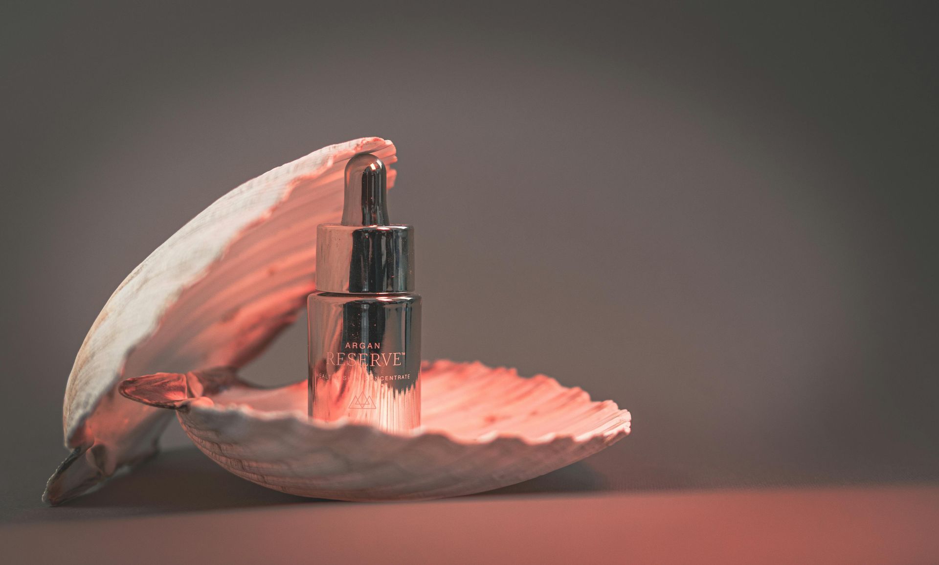 Una botella de perfume se encuentra dentro de una concha.